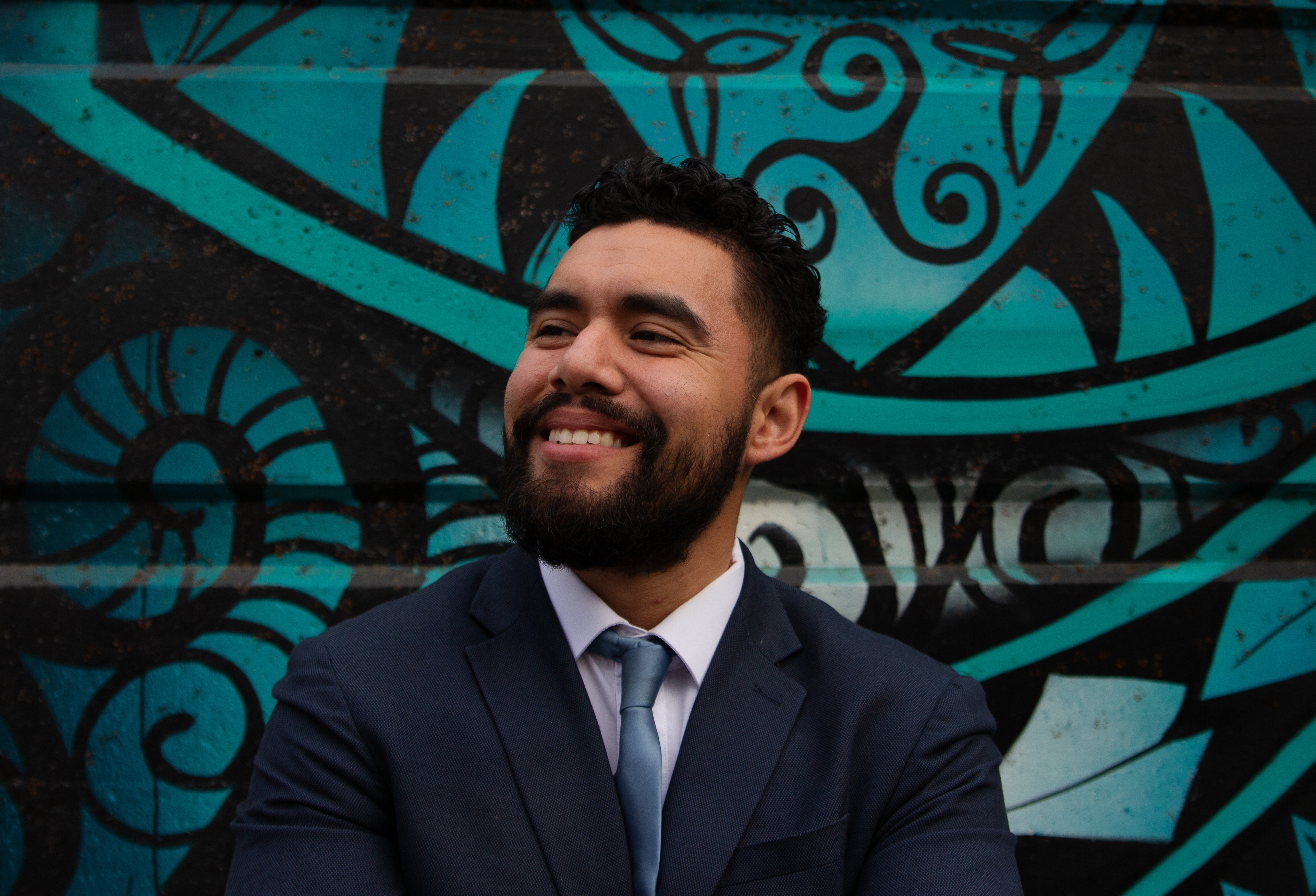 Antonio López standing in front of a mural on a garage